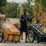 A rural African woman fetching clean water from a public tap in her village.