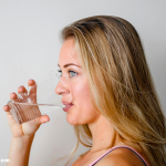 Woman drinking warm water in the morning for health benefits