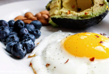Healthy morning foods including eggs, berries, oats, and avocado toast on a breakfast table.
