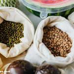 A flat lay of healthy superfoods like blueberries, spinach, yogurt, and salmon.