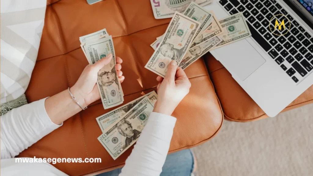 A freelancer working on a laptop beside a business owner in an office.
