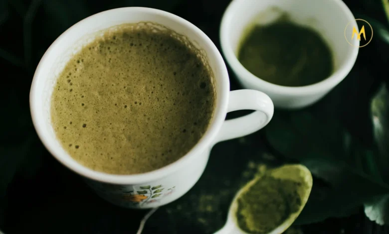 A cup of vibrant green matcha tea with bamboo whisk